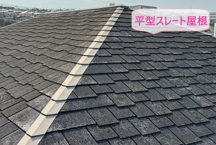 寄棟住宅の屋根重ね葺き工事で既存の平型スレート屋根がひび割れている様子