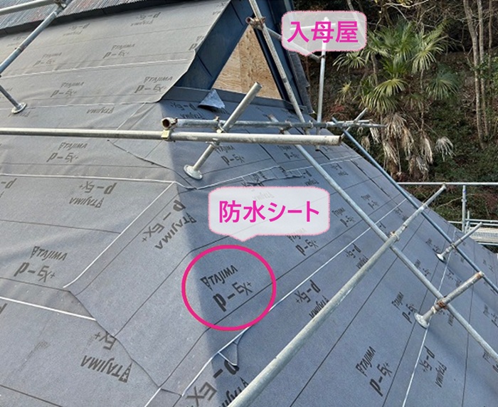 茅葺き住宅のカバー施工で防水シートを貼っている様子