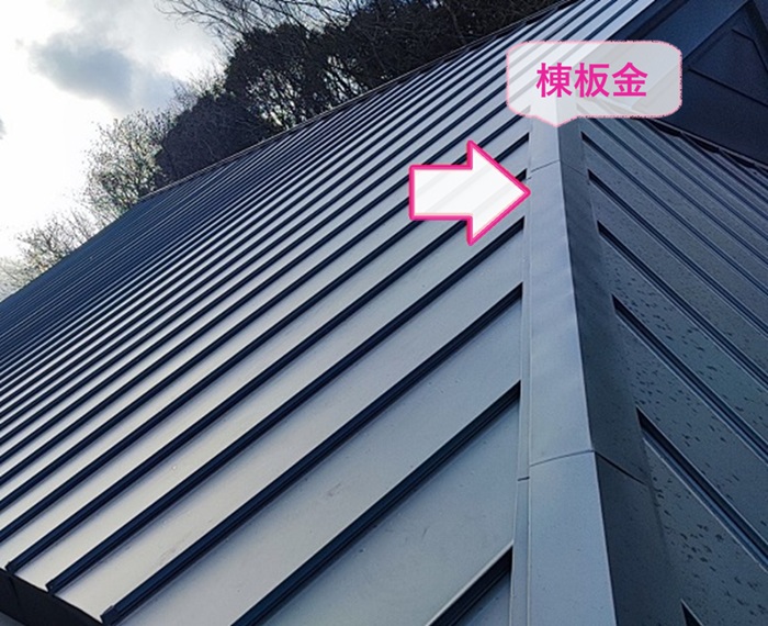 茅葺き住宅のカバー施工で棟板金を取り付けている様子