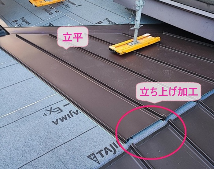 波型スレート屋根の葺き替え工事で金属屋根の立平を葺いている様子