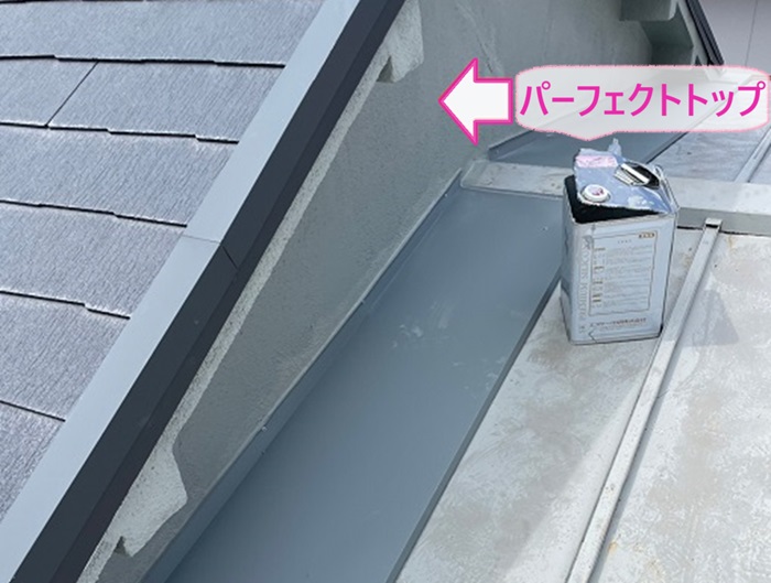 建て増し部分からの雨漏り補修でパーフェクトトップを外壁に塗っている様子
