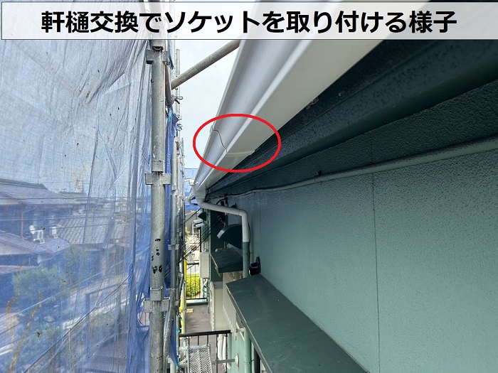 2階建てアパートの軒樋交換でソケットを取り付けている様子