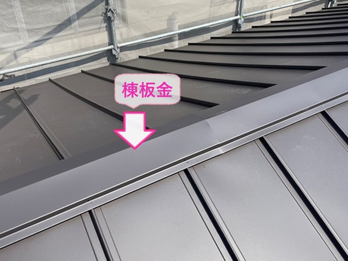 層間剝離する波型スレート屋根の改修工事で棟板金を取り付けている様子