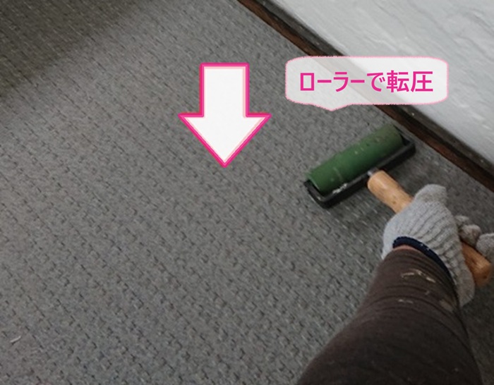 集合住宅の共用階段に貼ったタキステップをローラーで転圧している様子