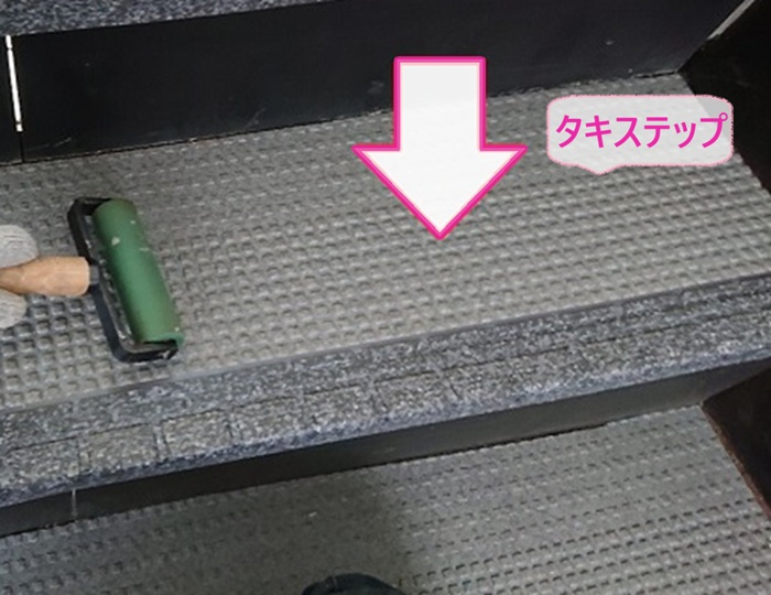 集合住宅の共用階段に新しいステップシートのタキステップを貼っている様子