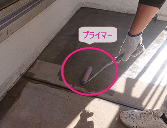 クラック対策する防水工事でベランダ床にプライマーを塗っている様子