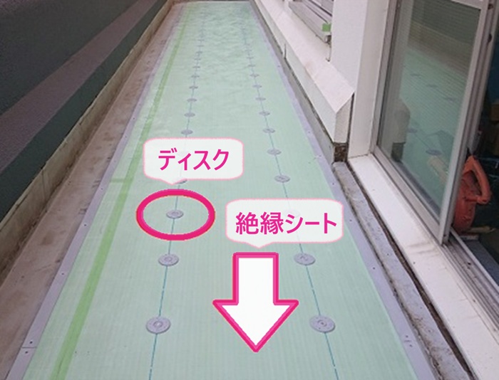 店舗ベランダの防水改修で絶縁シートを貼ってディスクを取り付けている様子