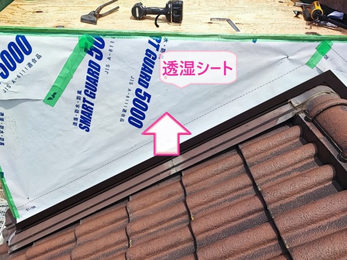 神戸市東灘区の屋根板金修理で浮いた外壁材の上から透湿シートを貼っている様子