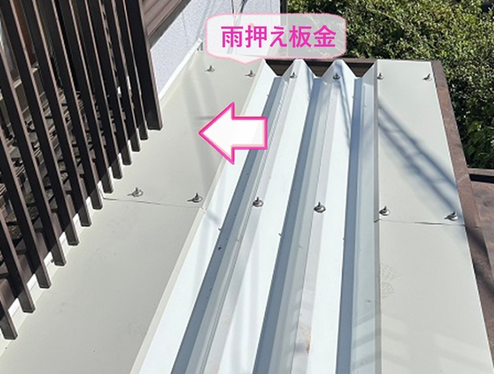 折板屋根リフォームで下屋根の壁際に雨押さえ板金を取り付けている様子