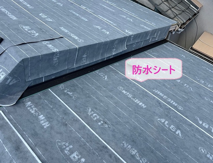 つながり屋根の貼り替え工事で防水シートを貼っている様子
