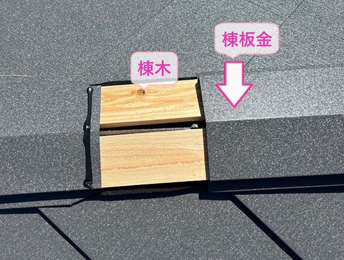 つながり屋根の貼り替え工事の仕上げに棟木と棟板金を取り付けている様子