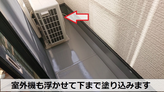神戸市兵庫区でベランダ塩ビシートの低価格なメンテナンスとしてVTコートを使用する現場で室外機の下も塗っている様子