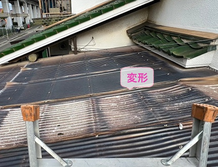 車庫屋根の張り替え工事で既存の波板が経年劣化で変形している様子
