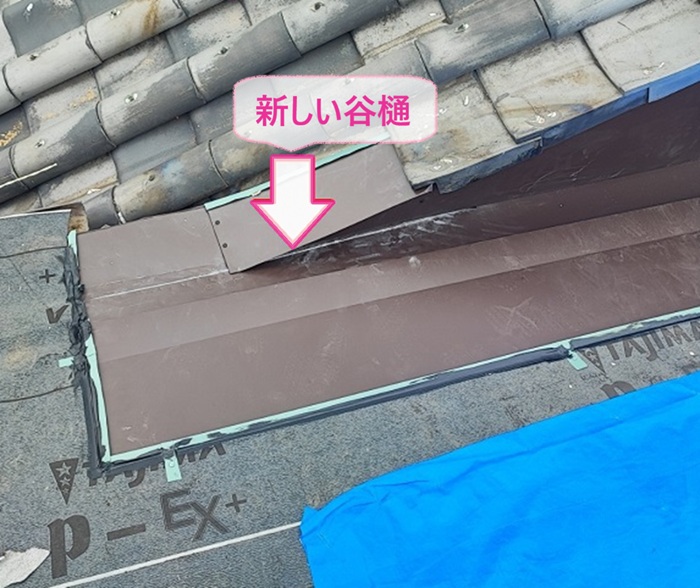 瓦屋根の部分補修で新しい谷樋のガルバリウム鋼板を取り付けている様子