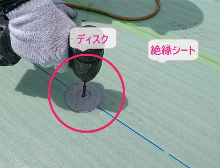 排水不良の屋上シート防水改修で絶縁シートを貼ってディスクを取り付けている様子