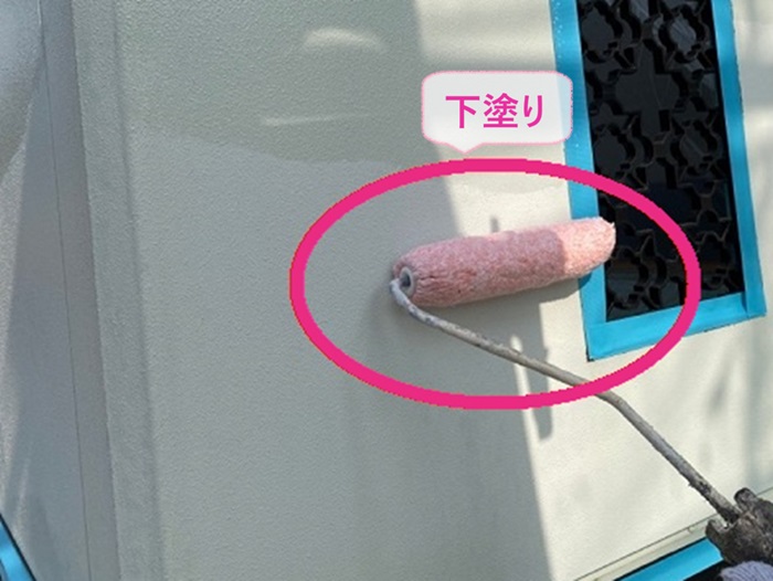 外壁リフォームで集合住居の外壁に下塗りしている様子