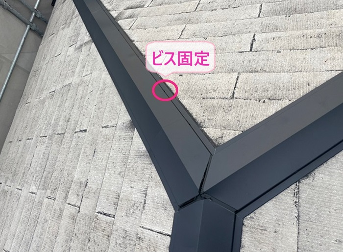 3階建てスレート屋根の棟補強で棟板金をビスで固定している様子