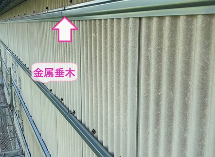 工場の外壁リフォームで既存の小波スレートの上に金属垂木を取り付けている様子