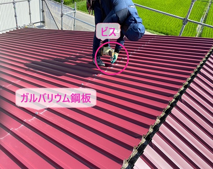 工場屋根の重ね葺きでガルバリウム鋼板製の屋根材をビスで固定している様子
