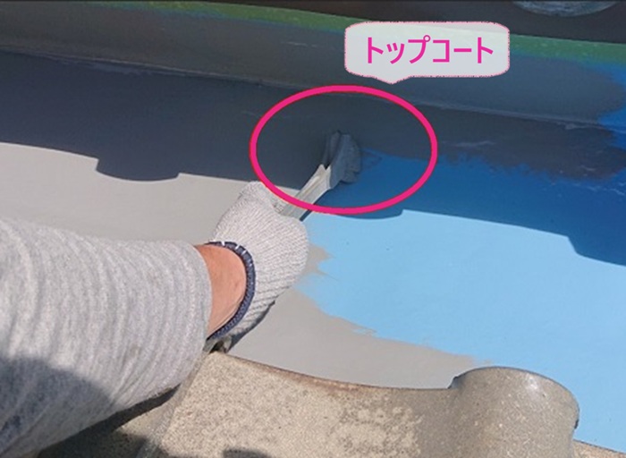 屋根谷部の劣化対策でトップコートを塗っている様子