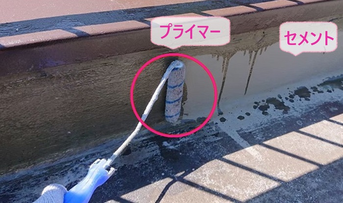 バルコニーの立ち上がり部分にセメントとプライマーを塗っている様子