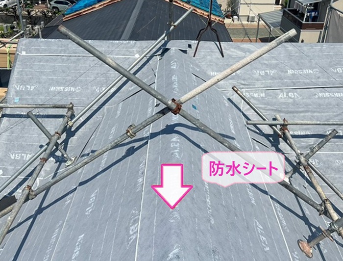 切妻屋根の改修工事で防水シートを貼っている様子
