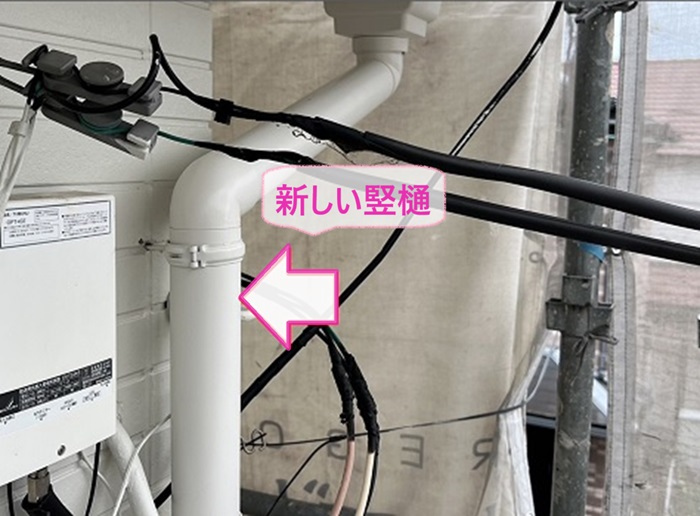 ２階の軒樋交換で新しい竪樋を取り付けて集水器と接合している様子