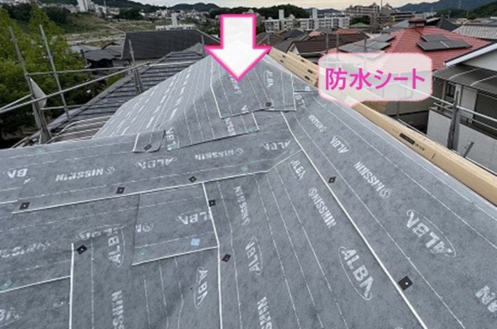 スレート屋根へのカバー工法で防水シートを貼っている様子