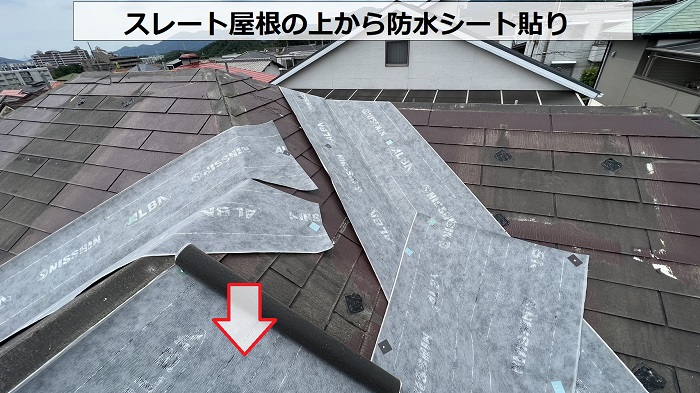 スレート屋根へのカバー工事で防水シートを貼っている様子