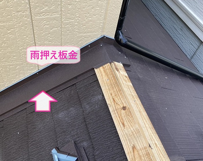 １階窓上の雨漏り修理で壁際に雨押さえ板金を取り付けている様子