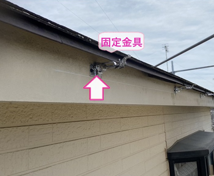 塩ビ鋼板雨樋を用いた雨樋工事で新しい固定金具を取り付けている様子