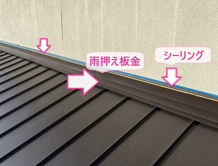 屋根貼り替え工事で壁際に雨押え板金を取り付けてシーリングを打設している様子