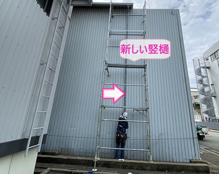 倉庫の排水パイプの交換で新しい竪樋を取り付けている様子