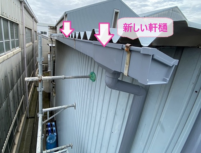 倉庫の排水パイプの交換で新しい軒樋を取り付けている様子