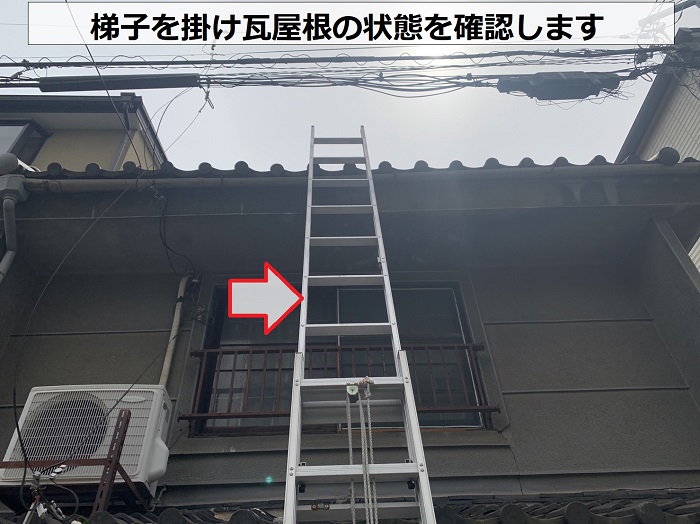 瓦屋根修理後の様子を確認するために梯子を掛けている様子
