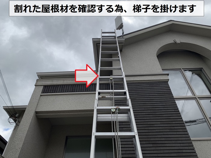 屋根点検で割れた屋根材を確認する為梯子を掛けている様子