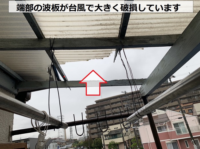 ベランダ屋根の端部が台風の影響で大きく破損している様子
