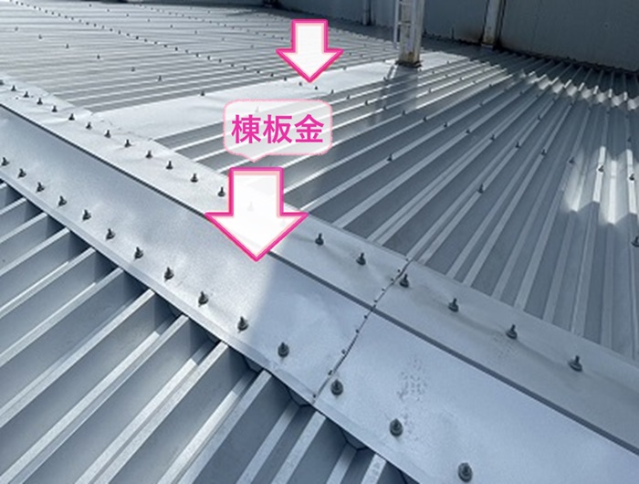商業施設の折半屋根の重ね葺きリフォームで棟板金を取り付けている様子