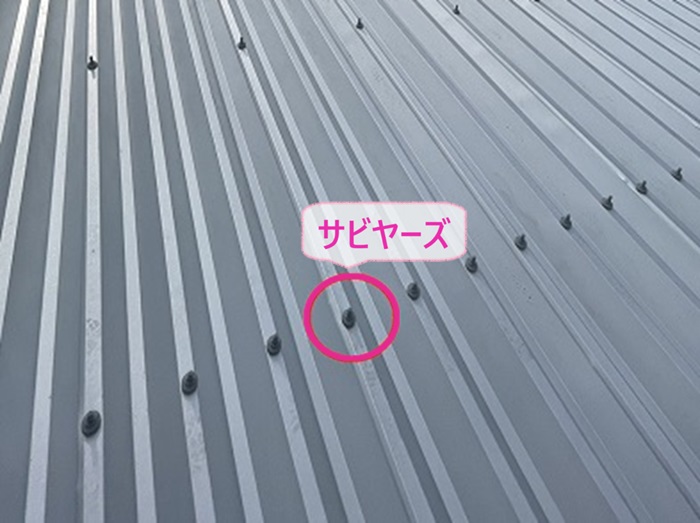商業施設の雨漏り修理で折半屋根の固定ボルトにサビヤーズを取り付けている様子