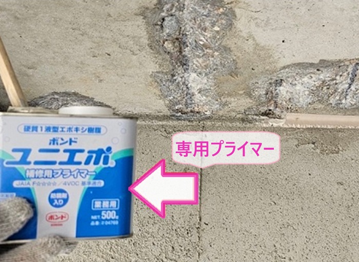地下ガレージの雨漏り補修で天井の剥がれてる部分にプライマーを塗っている様子