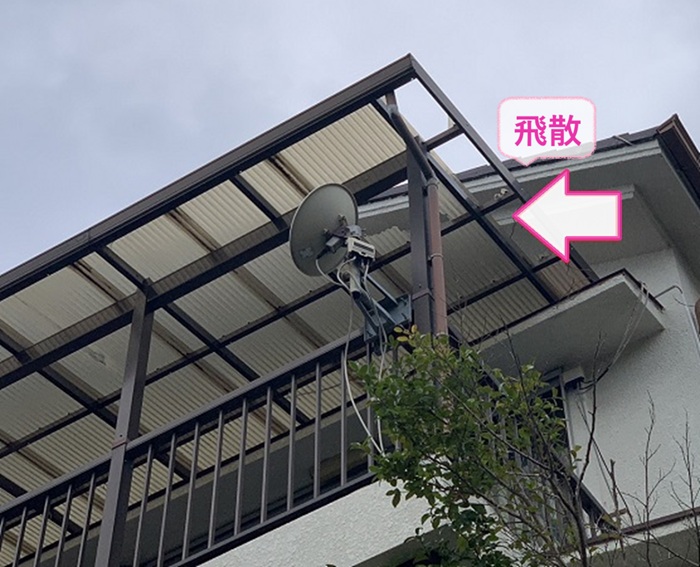 ベランダ屋根の破損修理で既存のポリカ波板が飛散している様子