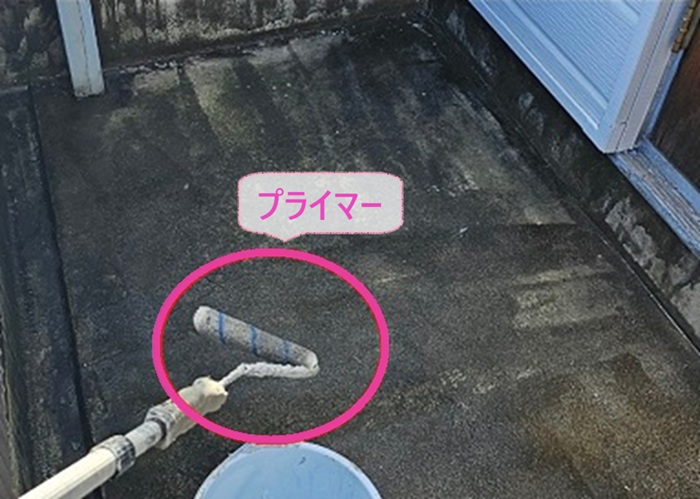 ２階建て集合住宅のベランダ防水工事でプライマーを塗っている様子