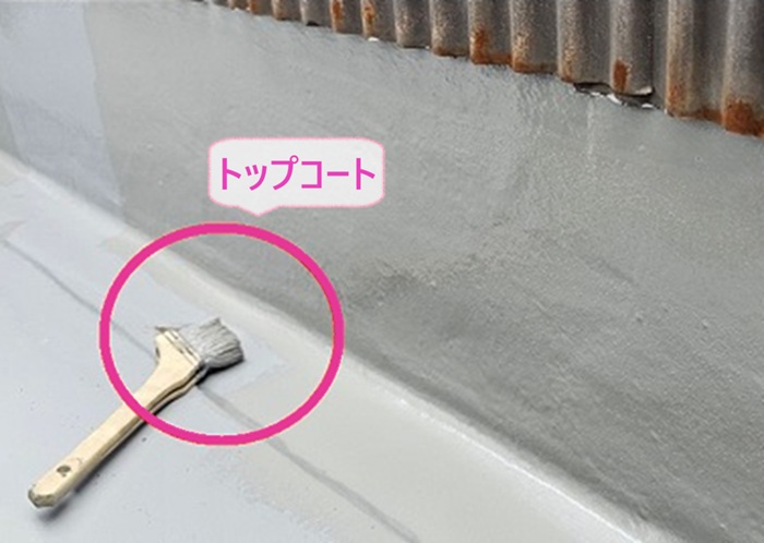 ２階建て集合住宅のベランダ防水工事でトップコートを塗っている様子