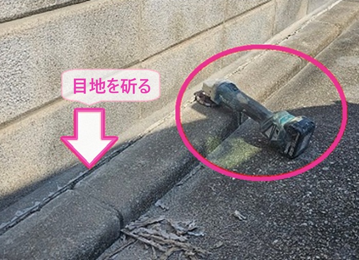 車庫コンクリート床の補修工事で入り口付近の目地を斫っている様子