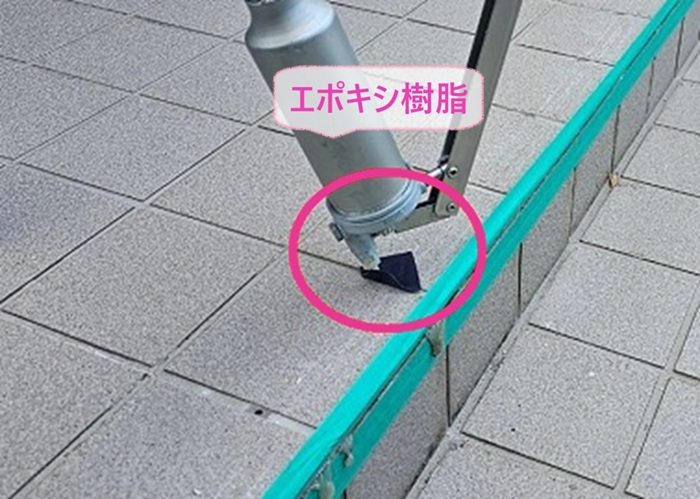 玄関土間の陶器タイルの欠け補修で穴を開けた部分にエポキシ樹脂を注入している様子