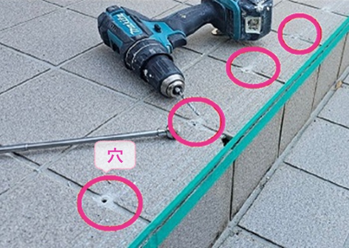 玄関土間の補修でタイル目地に等間隔で穴を空けている様子