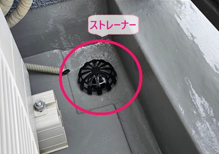 バルコニーの防水工事で排水ドレンに落ち葉除けのストレーナーを取り付けている様子