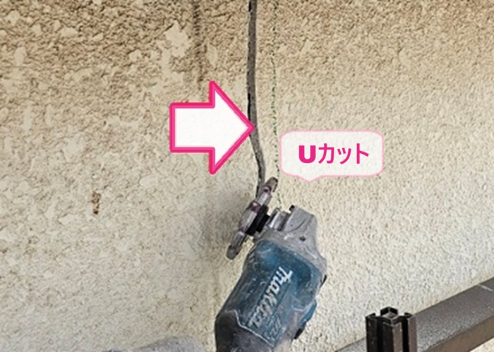 戸建て外壁でモルタル壁のひび割れ部分をUカットしている様子
