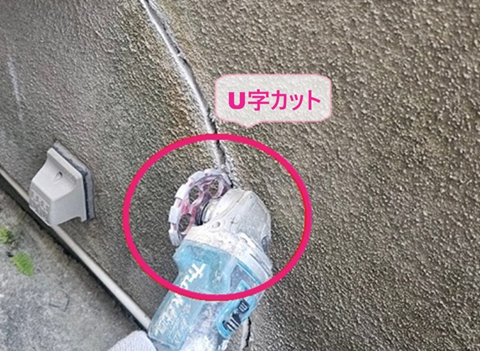 モルタル壁の部分修理工事でひび割れ部分をUカットしている様子