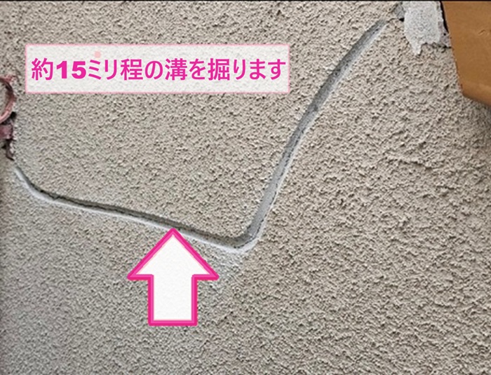 モルタル壁の部分修理工事で15ミリくらいの溝を掘っている様子